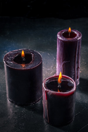 Burning candles, purple, on a dark background, mysterious ritual, with copy spaceの写真素材