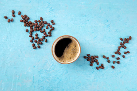Coffee cup and coffee beans, top shot on a blue background with copy space, menu banner design, a flat lay compositionの写真素材