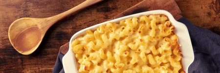 Macaroni and cheese pasta in a casserole panorama, overhead flat lay shot on a rustic background...