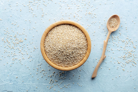 Quinoa in a wooden bowl, healthy organic wood, uncooked, overhead flat lay shotの写真素材