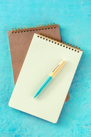 Notebook mockup with a pen, top shot on a teal backgroundの写真素材