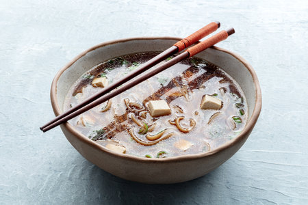 Tofu soup, Japanese cuisine. Miso soup with bean curd and green onions, with soba, buckwheat noodles, and chopsticksの写真素材