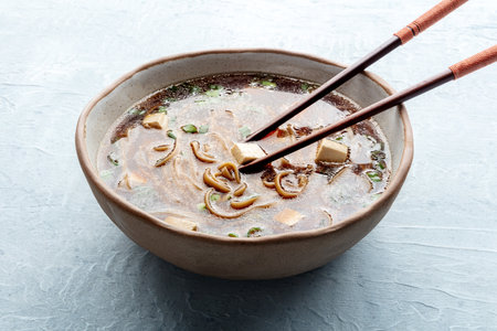 Eating tofu soup, Japanese cuisine. Miso soup with bean curd and green onionsの写真素材