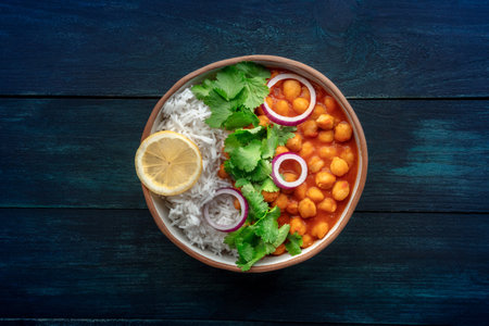 Chana masala, chickpea curry, traditional Indian dish, overhead flat lay shot on a dark blue wooden backgroundの写真素材