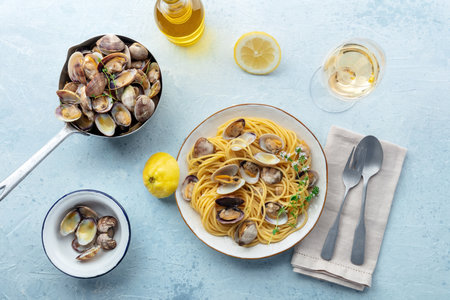 Vongole clams with spaghetti pasta, with white wine, overhead flat lay shot. Seafood dish with lemon, thyme, and olive oilの写真素材