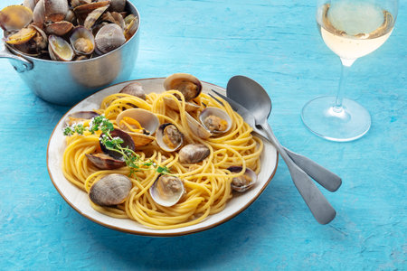 Vongole clams with spaghetti pasta, with white wine. Seafood linguine on a blue backgroundの写真素材