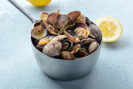 Vongole clams in a saucepan with thyme, lemon, and olive oil. Seafood sauce, Mediterranean cuisineの写真素材