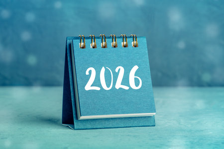 2026 Calendar. A desk calendar for the next year, shot on a blue background with bokeh, with handmade letteringの写真素材