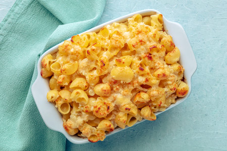 Mac and Cheese, macaroni pasta, oven-baked in a casserole with cream, overhead flat lay shot on a...