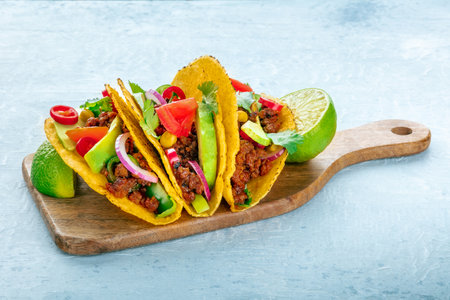 Ground beef tacos on a wooden board, Mexican food, with limesの写真素材