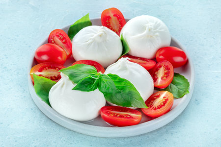 Buffalo Mozzarella, fresh cherry tomatoes, and basil leaves, Italian Caprese saladの写真素材