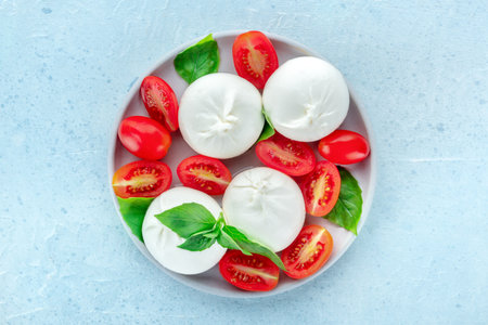 Mozzarella, fresh cherry tomatoes, and basil leaves, Italian Caprese salad, overhead flat lay shotの写真素材