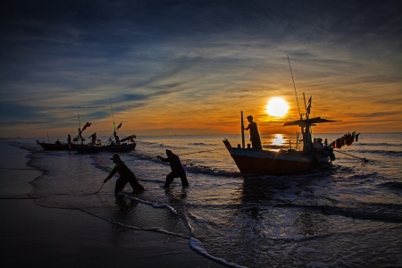 silhouette of fisherman with sunrise in the background