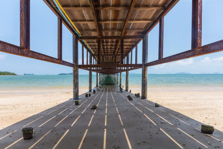 under the wooden bridge at a beautiful beach on sunny day in Thailnd 