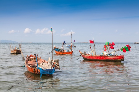 Traditional fishing boat anchoring near a beach の写真素材