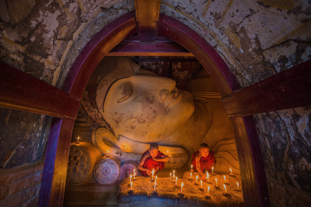 BAGAN, MYANMAR - JAN 15,2015: Unidentified young Buddhism monks praying with candle light at Shwesandaw temple on January 15, 2015 in Bagan, Myanmar. Buddhism is predominantly of the Theravada tradition, practised by 89% of the population.のeditorial素材