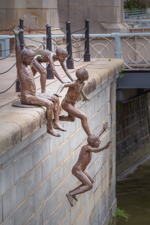 SINGAPORE-30 AUGUST 2014: Raffles place, a statue of kids jumping to the river in front of The Fullerton Hotel on August, 2014.のeditorial素材