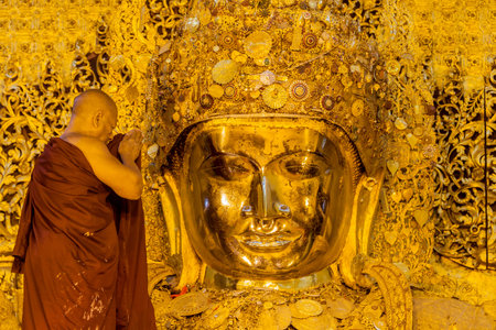 Mandalay, Myanmar-January 25: The senior monk wash Mahamuni Buddha image in ritual of the Buddha image face wash every morning at 4am. on January 25,2013 at Mahamuni temple in Mandalay, Myanmar.のeditorial素材