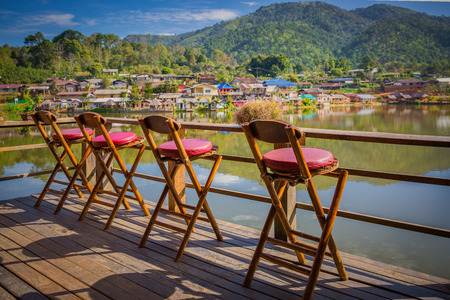 Lonely empty chairs on a deck at rak Thai Village in Mae Hong Son province, Thailand. for traveler to sit and relax. Travel and Relax concept.の写真素材