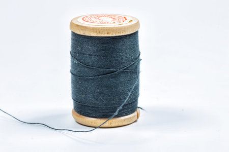 Black thread on a wooden spool.