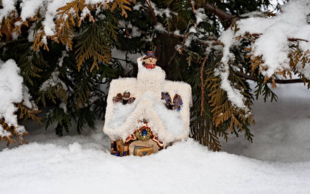 The toy lodge of snowmen costs in a snowdrift, lit with the sun.の写真素材