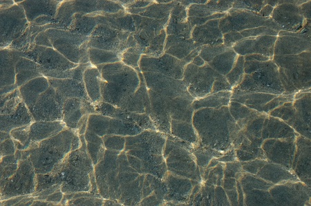 Sunlit waves on shallow sandyの写真素材