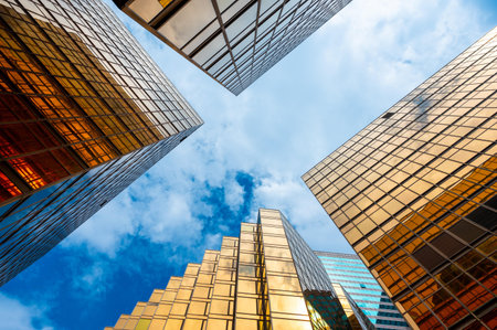 Golden skyscrapper building with blue sky in Hong Kong. Windows glass of modern office architecture design. Architecture exterior for cityscape background.