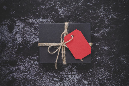 A black gift box placed on a black plaster background.....