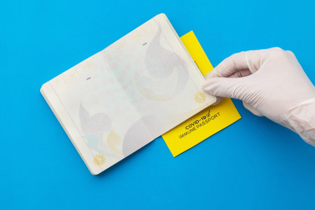 Hand holding vaccine passports as proof that the holder has been vaccinated against Covid-19, Requirement for international travel.