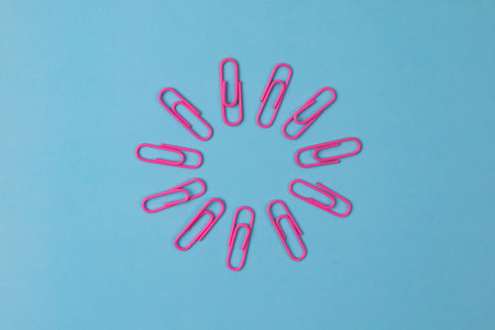 Color paper clips isolated on paper background
