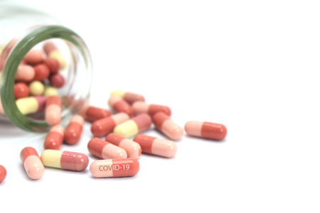 Medicine capsule covid-19 and bottle on white background. Focus on pills
