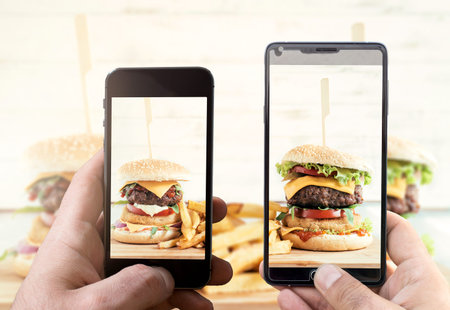 Men shooting with their cell phone camera big and tasy burgers.Selective focus on the phone