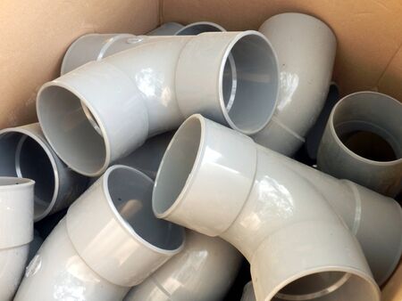 Cardboard box full of drainage pipe jointsの写真素材