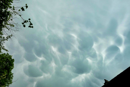 A rare and ominous looking example of a Mammatus cloud formation, formed by pouches or bulges hanging from the base of a cloudの写真素材
