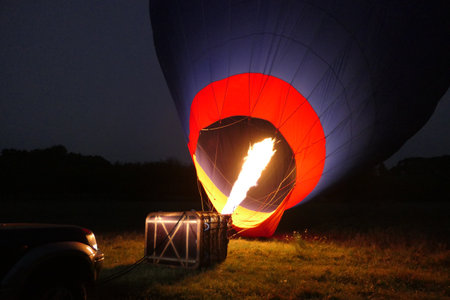 Flame from a propane burner inflating a hot air balloon in preparation for a dawn flightの写真素材