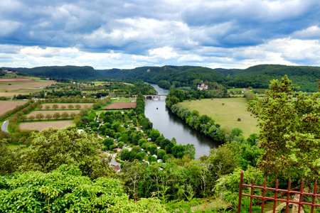 View of the River Dordogne flowing through the landscape as seen from the top of Beynac et Cazenac a fortified town in the Dordogne, Franceの写真素材