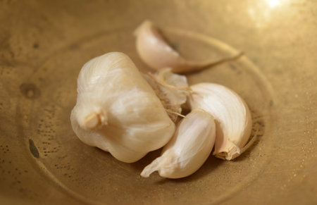 Garlic on a copper plate, close-up, selective focusの写真素材