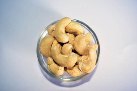 Cashew nuts in a glass bowl on a white background, top viewの写真素材