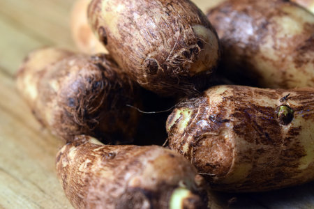 Group Of Unpeeled Taro Root Vegetable On Wooden Table  Imageの写真素材