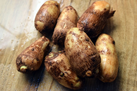 Group Of Unpeeled Taro Root Vegetable On Wooden Table  Imageの写真素材
