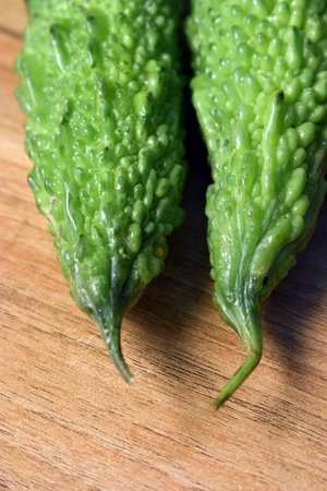 Fresh Green Bitter Melon Or Bitter Gourd On Wooden Table Close Up With Background Blur Imageの写真素材