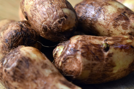 Group Of Unpeeled Taro Root Vegetable On Wooden Table  Imageの写真素材