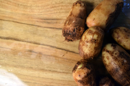 Group Of Unpeeled Taro Root Vegetable On Wooden Table  Imageの写真素材