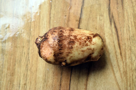 Fresh Taro Root Vegetable On Wooden Table Close Up With Background Blur  Imageの写真素材
