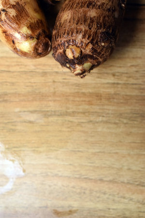 Group Of Unpeeled Taro Root Vegetable On Wooden Table  Imageの写真素材