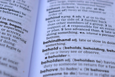 Close Up Of English Dictionary Page With Word - behindhand