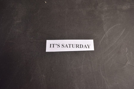 Itâ€™s Saturday paper note on black textured background with minimalist designs