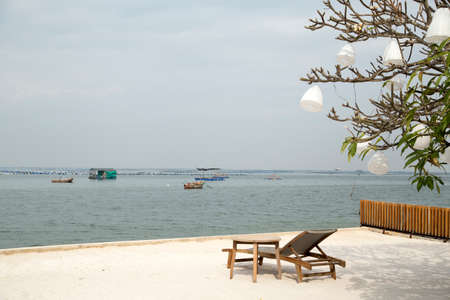 Beach chair and fisherman boatsの写真素材