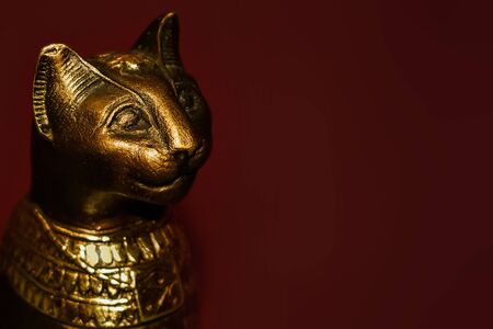 Figure of ancient Egyptian cat on Maroon background with mock up spaceの写真素材