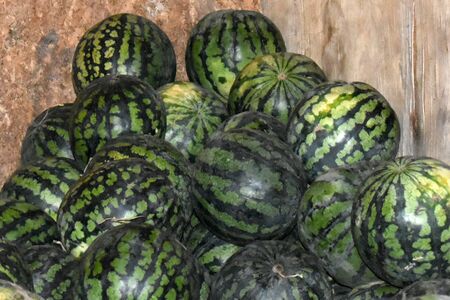 Many green mature watermelons lays in wooden box for tradingの写真素材